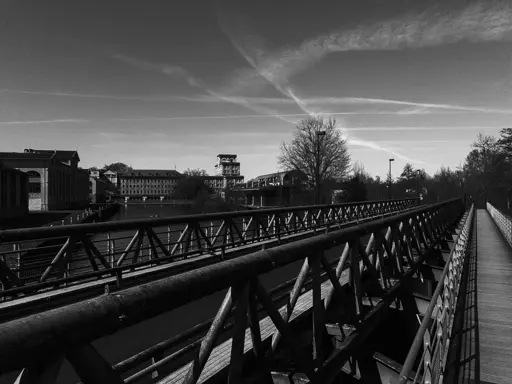 Monochrome outdoor daylight photo.
Despite the metallic bridge flowing to the right taking like half of the foreground image, i hereby proclaim this is a view of an ancient chocolate factory.