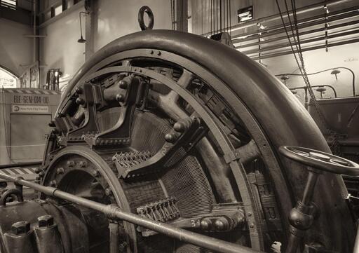 An early 20th century electromechanical "rotary converter", resembling a generator, in an industrial space