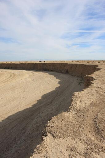 A sharp-edge and very large, deep wash in the desert.